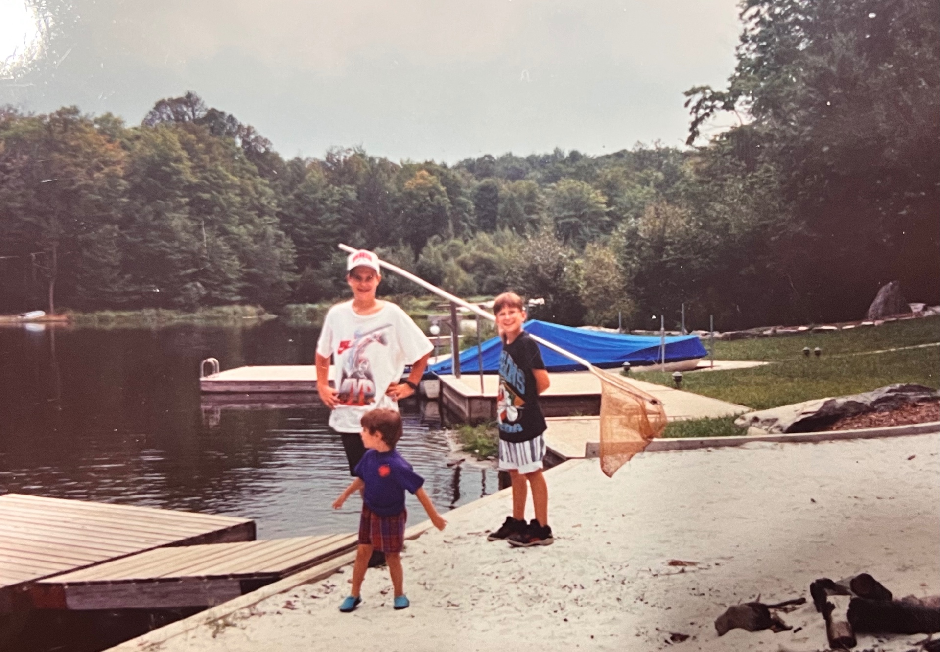 Chris on the left, Francis in the middle, Jason on the right — nets in hand, the lake behind them, another Hideout summer day