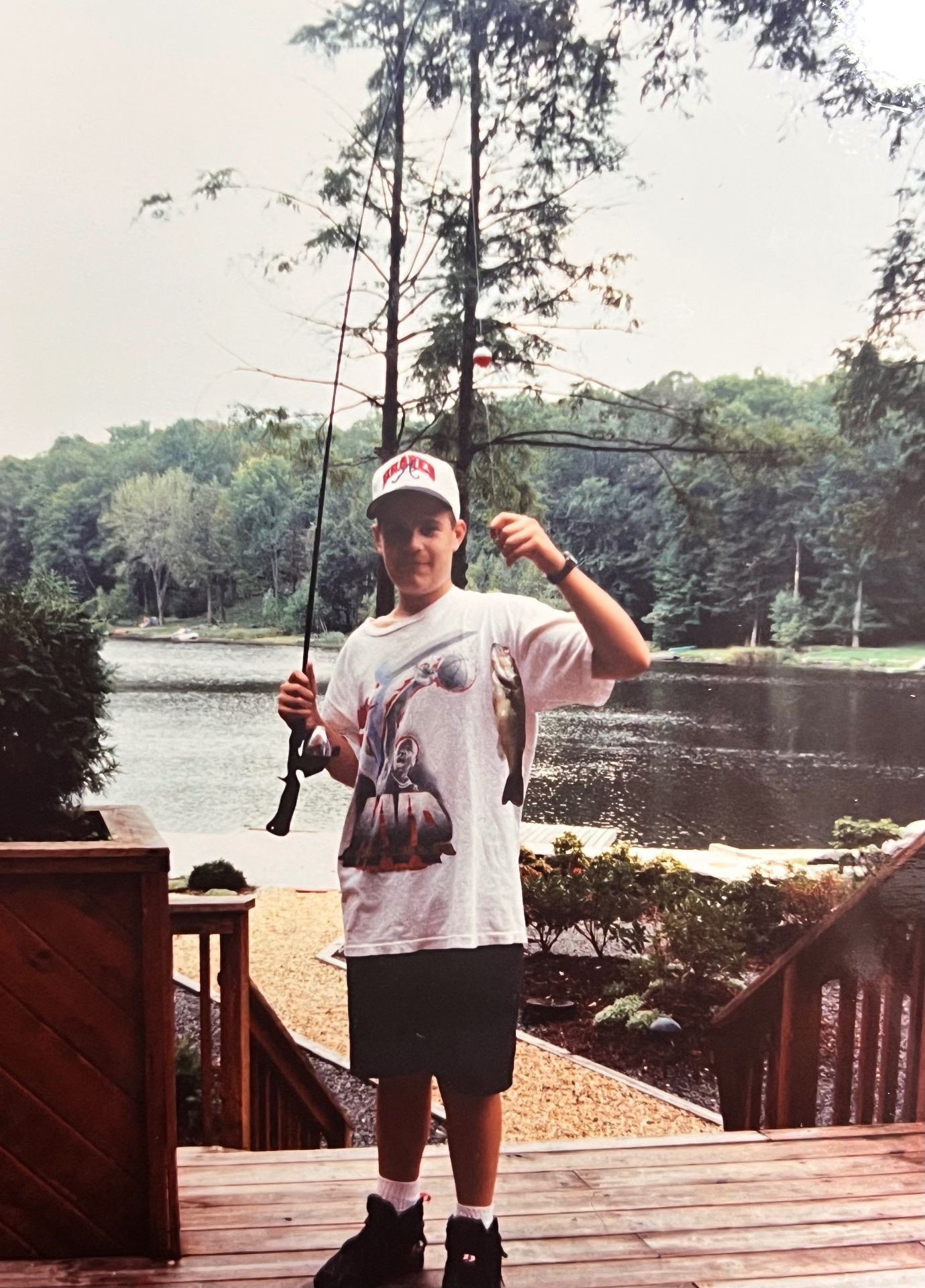 Chris on the deck with a nice one on the line — rod up, grin bigger than the fish