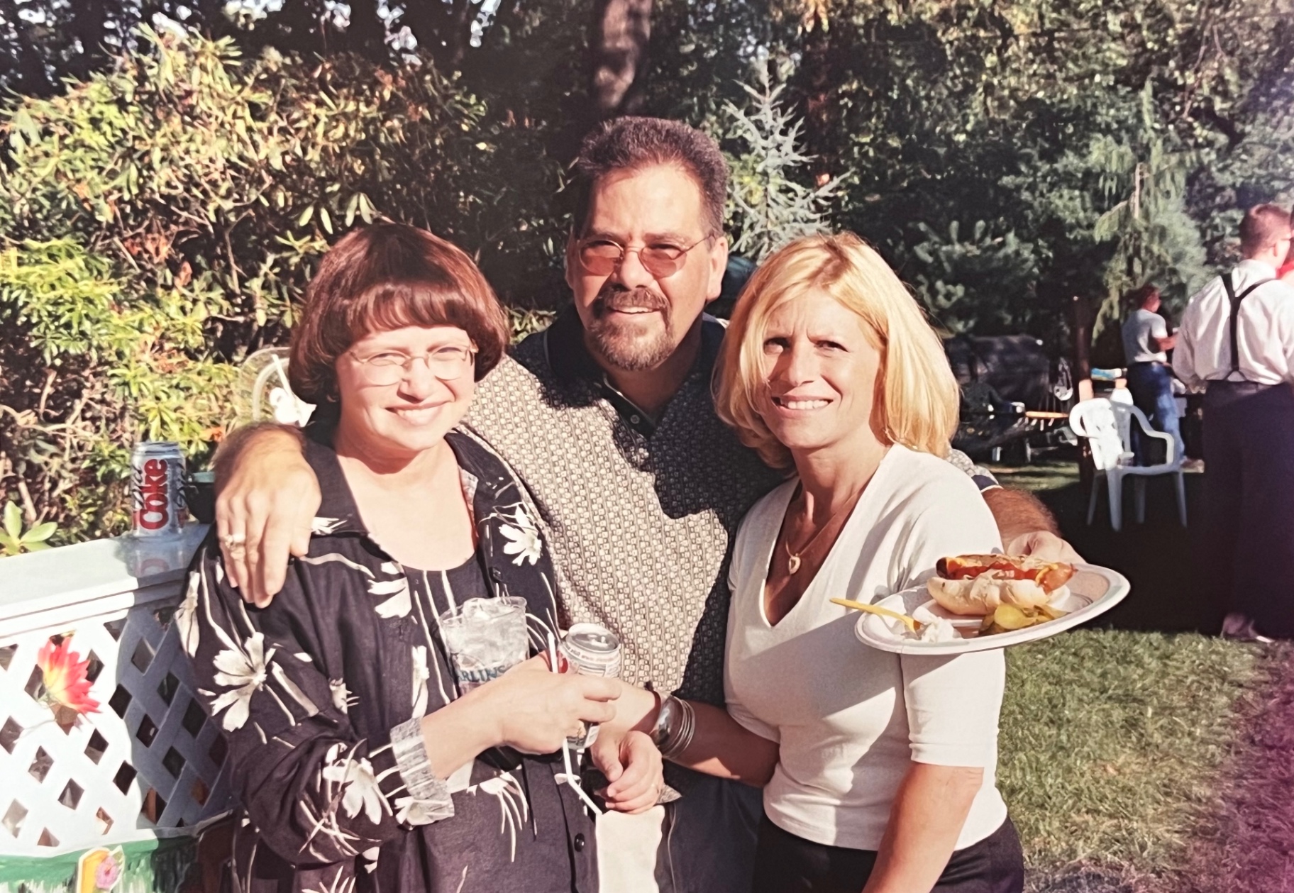 Golden hour — plates full, arms around each other, the party in full swing