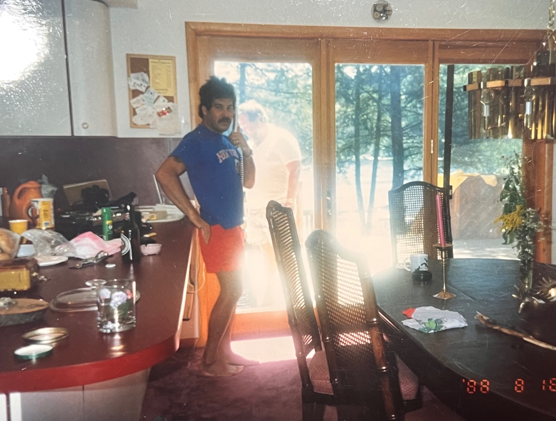 Richard in the Hideout kitchen — phone to his ear, sunlight pouring through the pines, right where he belonged
