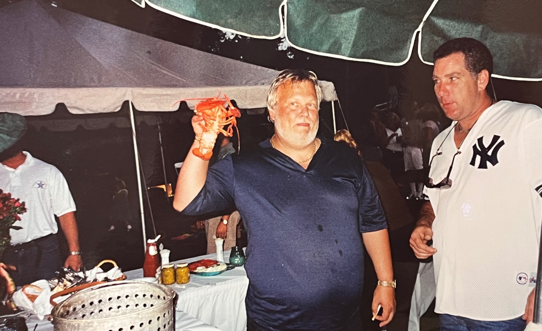 The King of the Bake — Richard hoisting a fresh lobster high, the crown jewel of the night