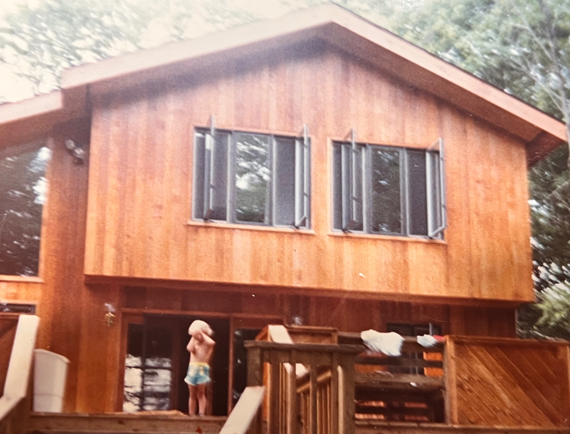 One of the boys on the fresh cedar porch — The Hideout finally taking its true shape