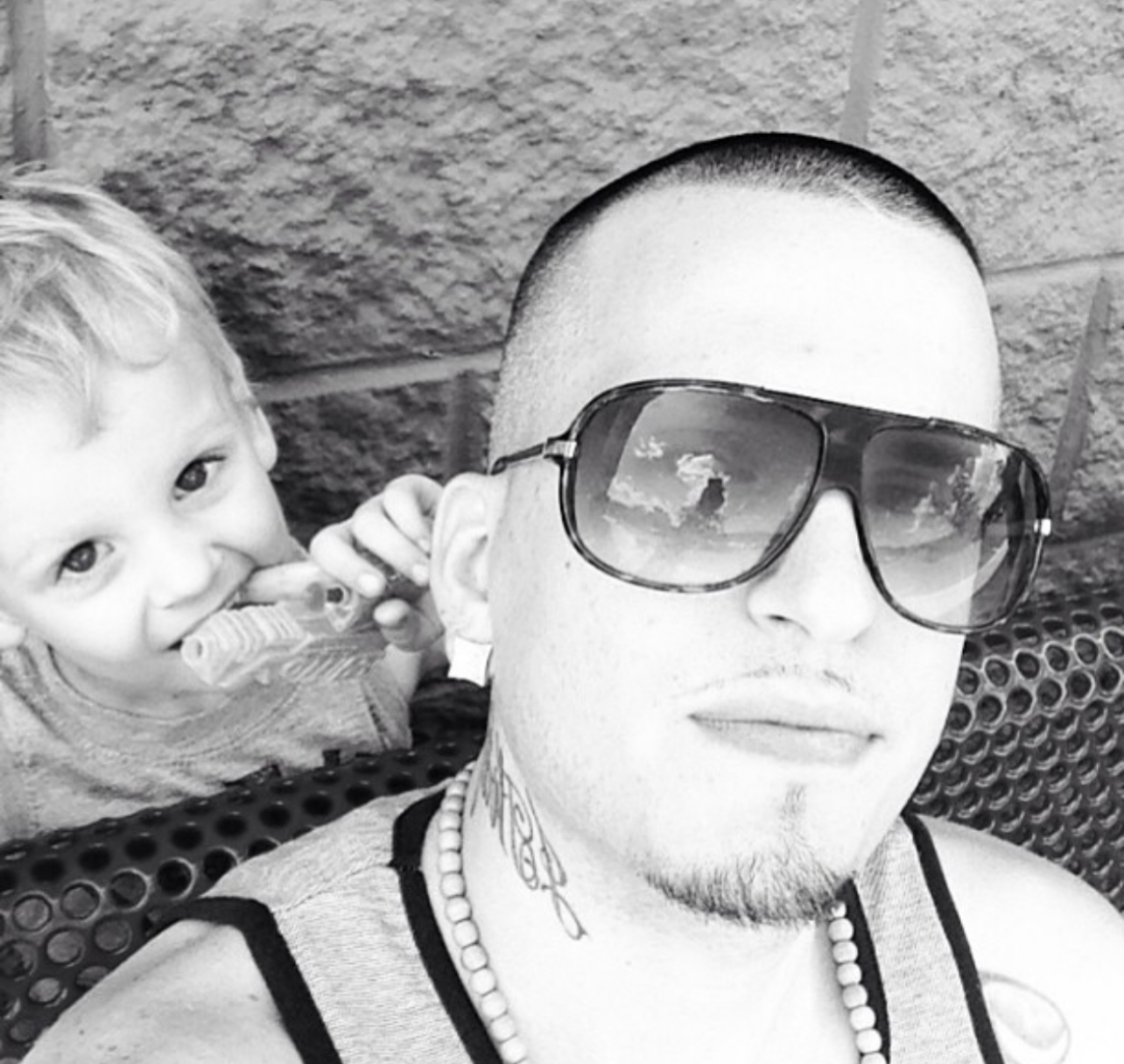 Sean sneaking a popsicle behind Dad — a moment frozen in black and white