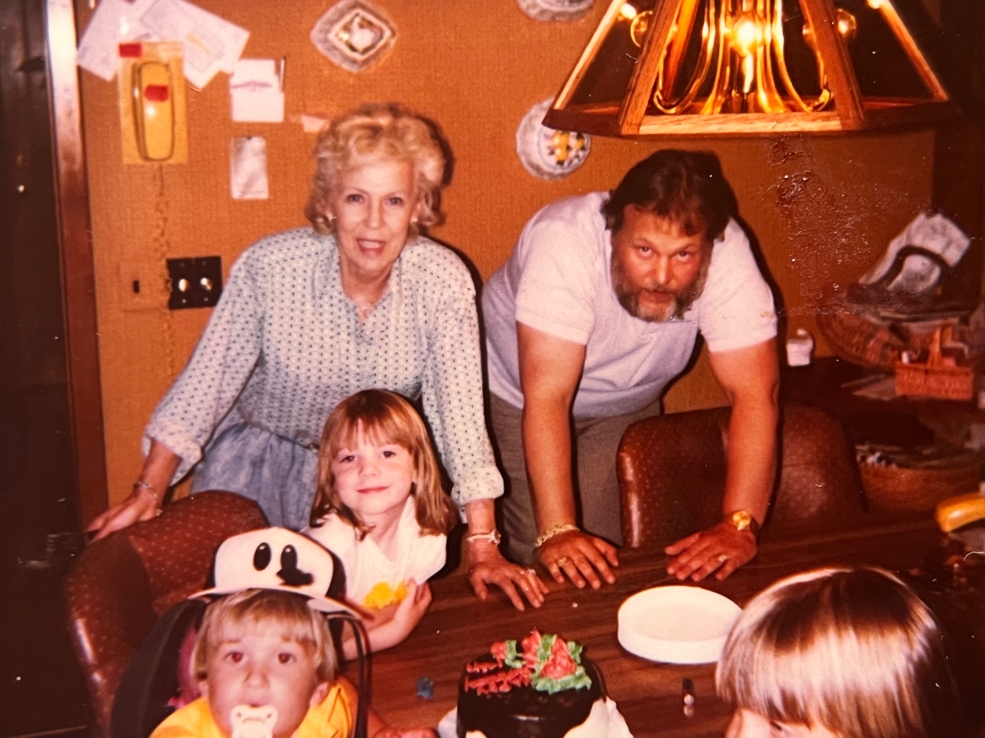 Bob & Gloria with the grandkids — cake, smiles, and a house full of love