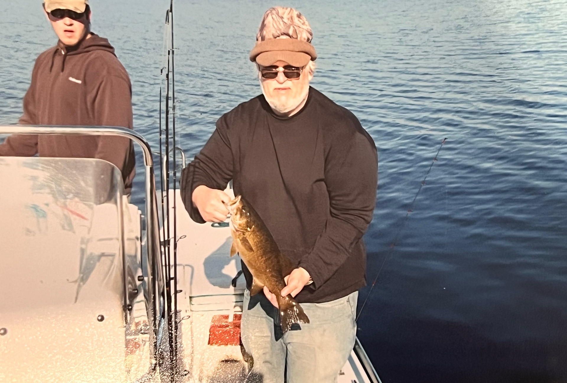 Bundled up against the cold — a solid bass in hand, deep blue Canadian water