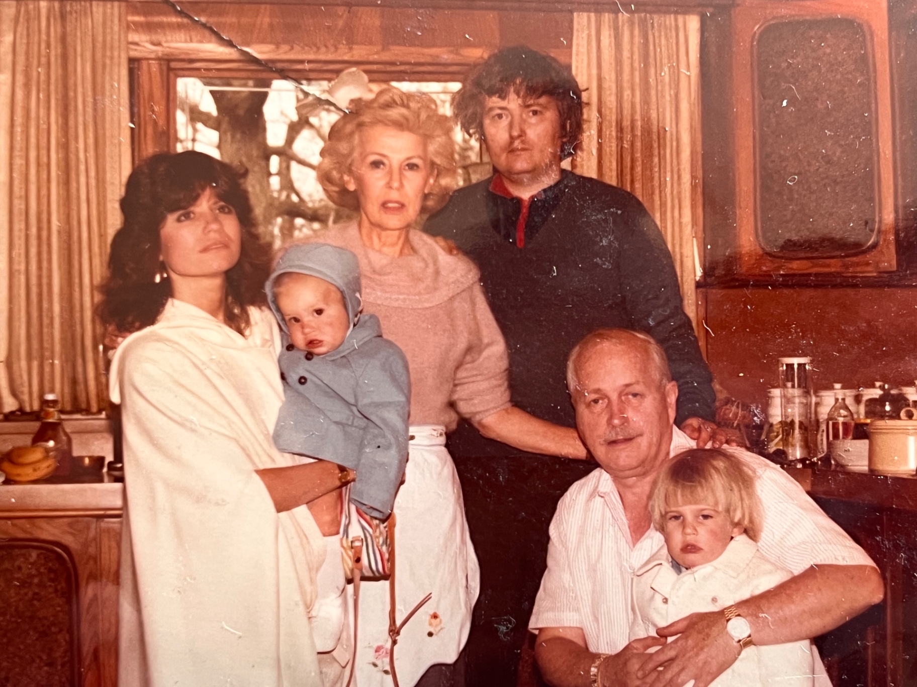 The kitchen full of family — grandparents, parents, and little ones, exactly the way he liked it