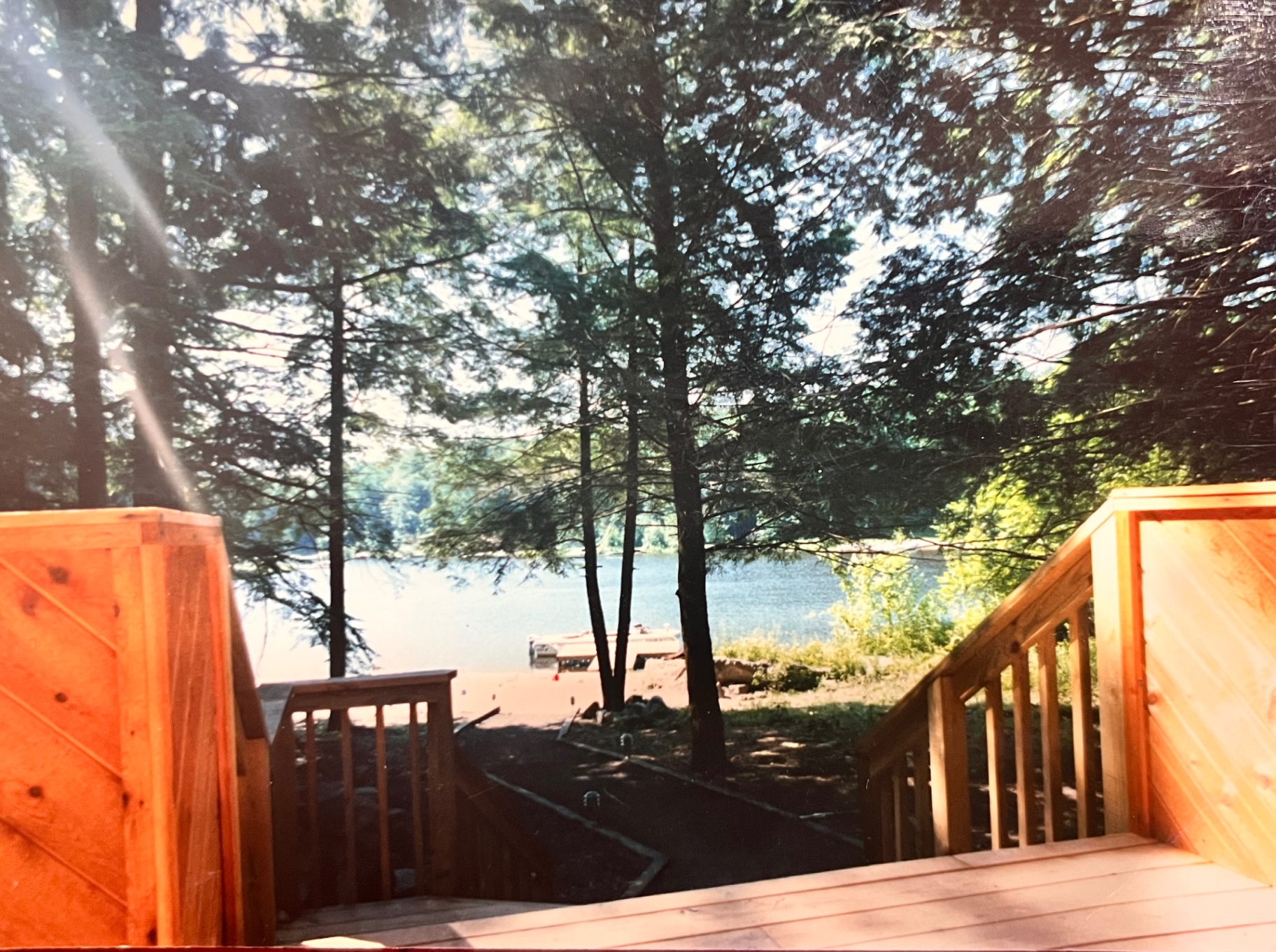 Sun through the pines, the lake just beyond the deck — the view he built the whole place around
