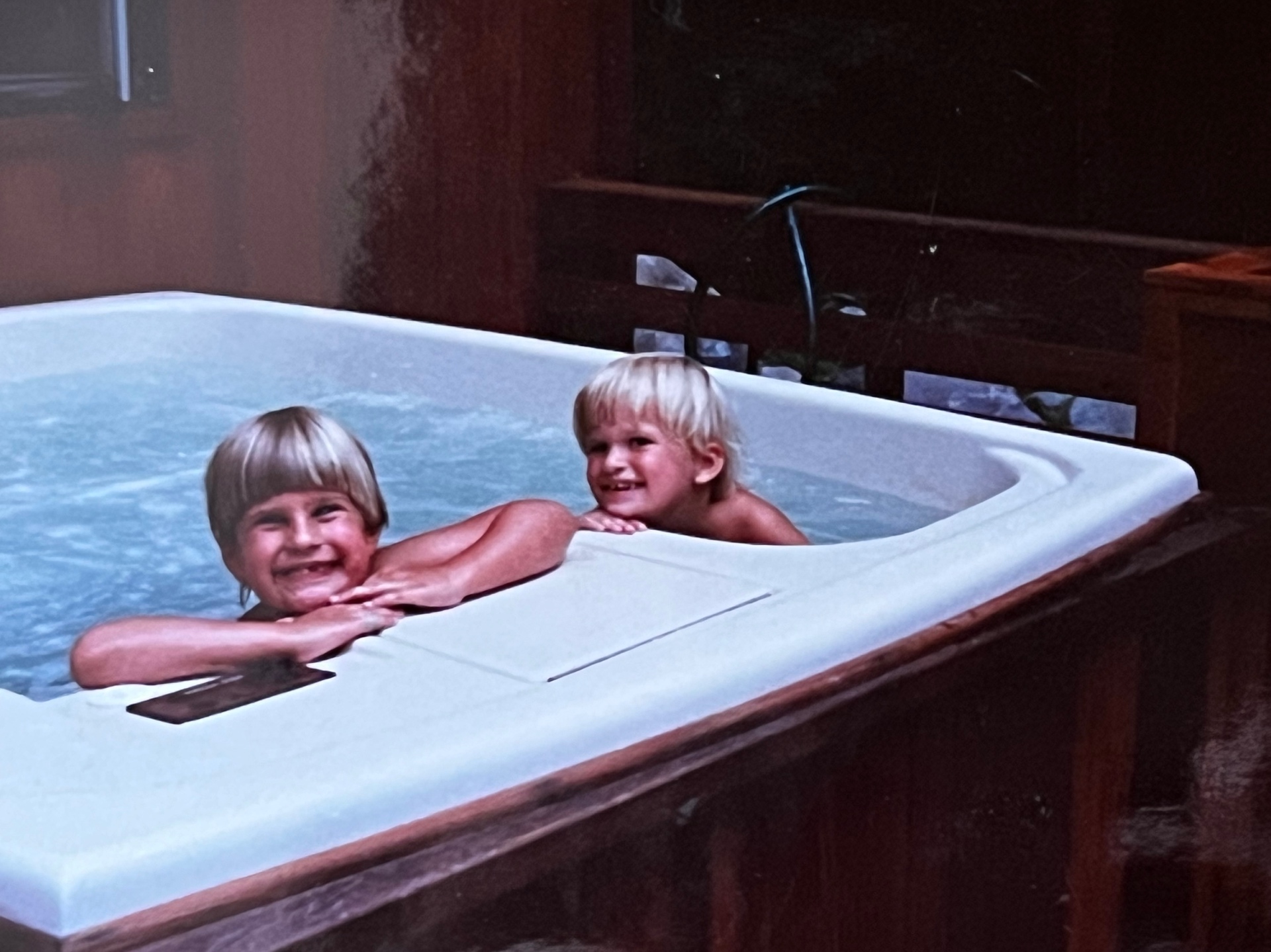 Two little blond brothers in the hot tub — grinning through another cozy family getaway