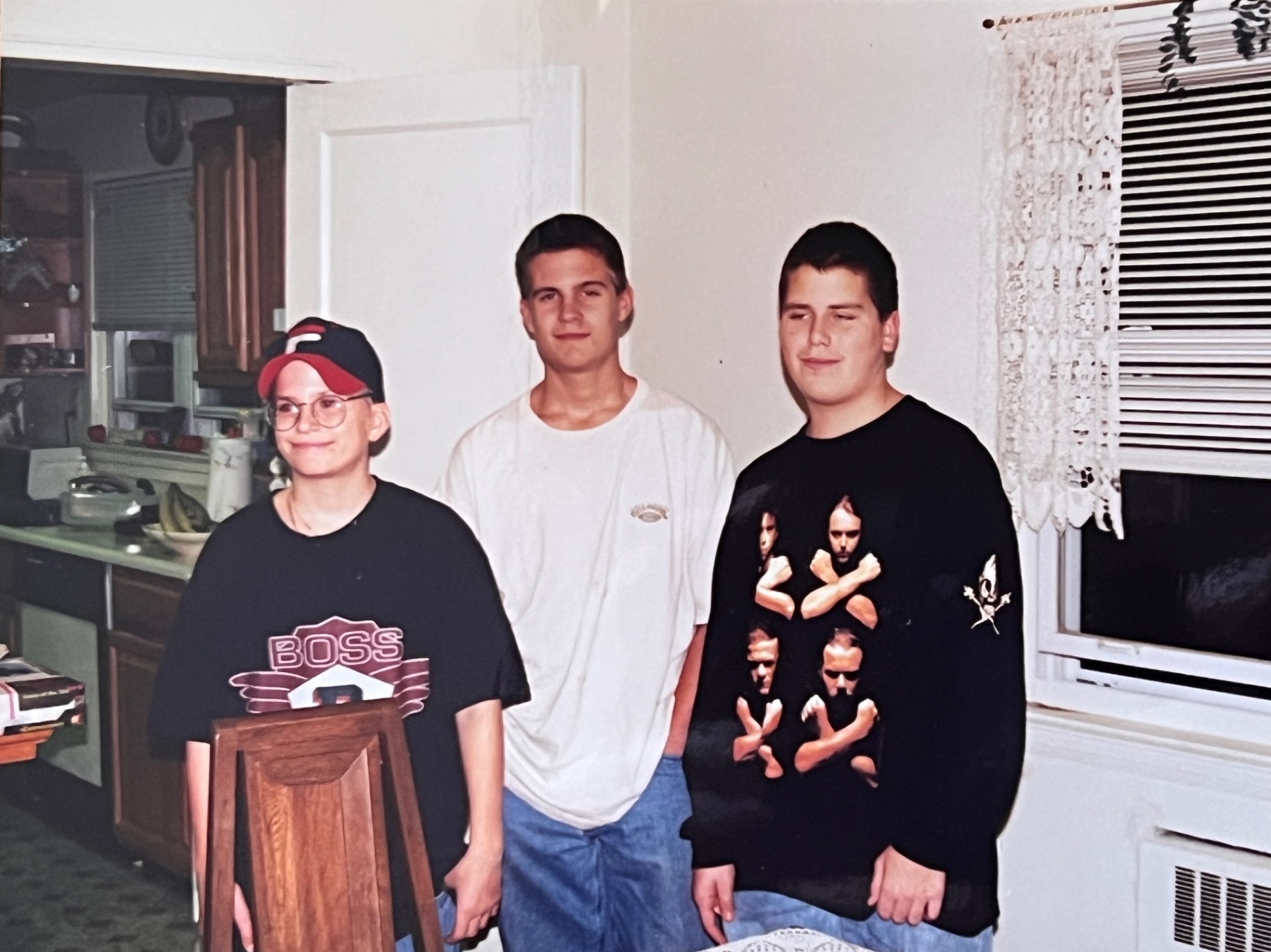 Three brothers in the kitchen — late-teen years, familiar walls, and a house full of memories