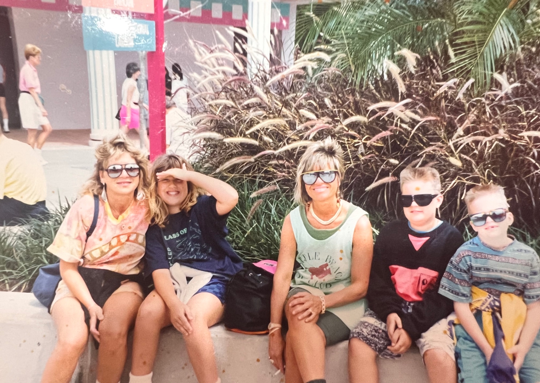 The whole crew taking a break in the shade — moms, cousins, brothers, and everyone in sunglasses. A Bladis vacation in one frame