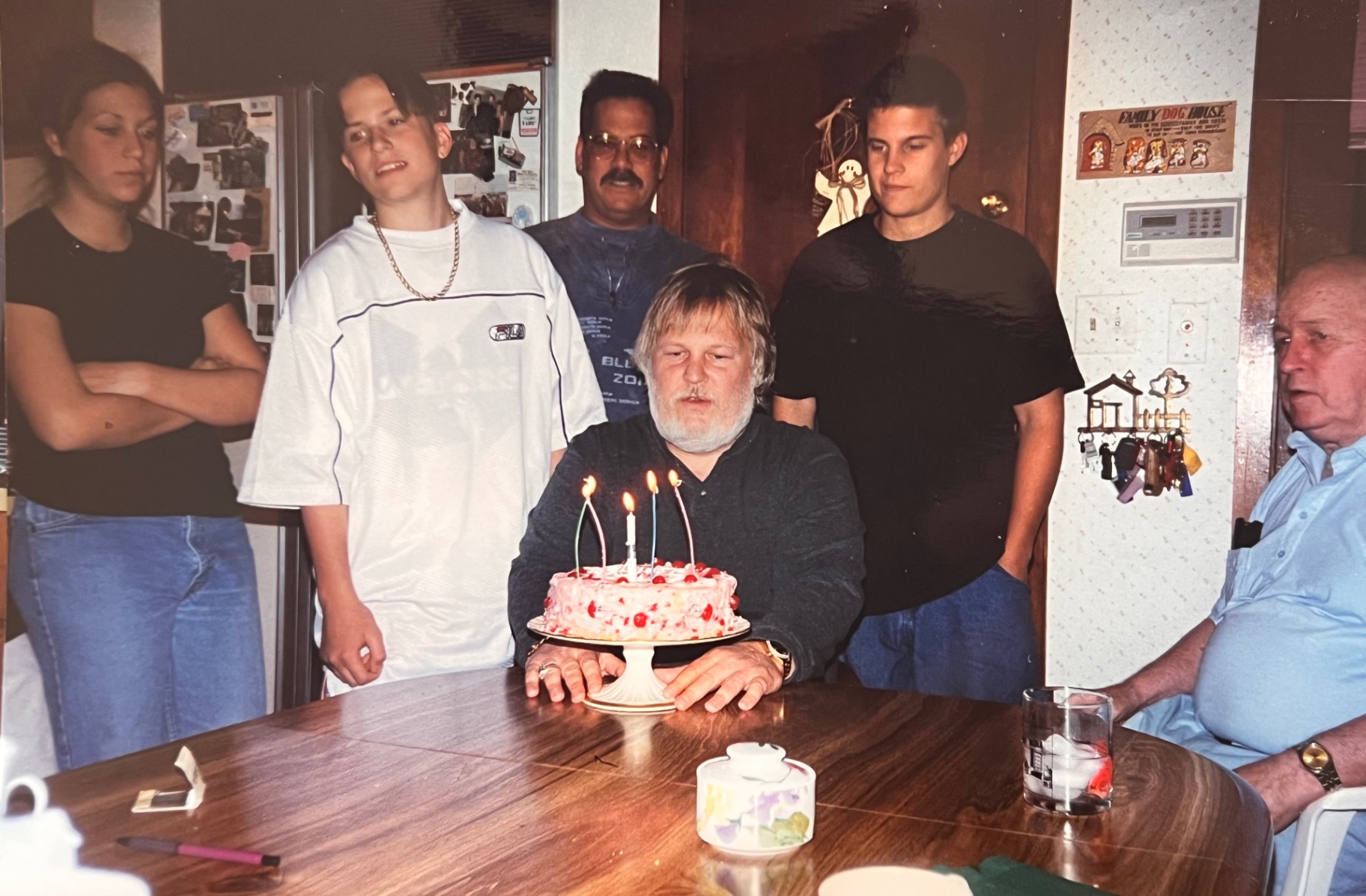 Three generations around Dad's birthday cake — the light was bright and the room was full