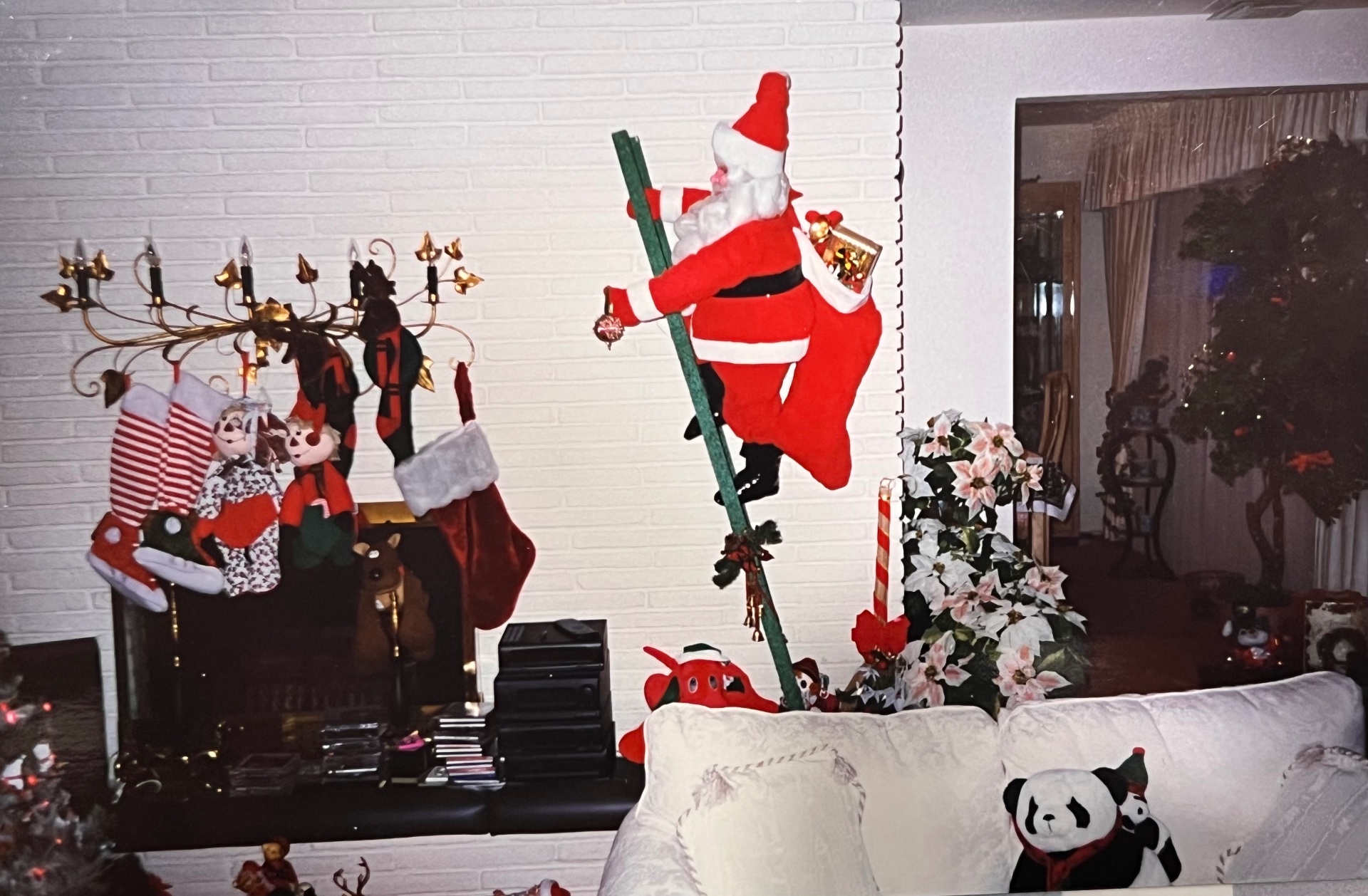 Santa climbing the ladder by the stockings — Grandma Gloria's living room, dressed to the nines for Christmas