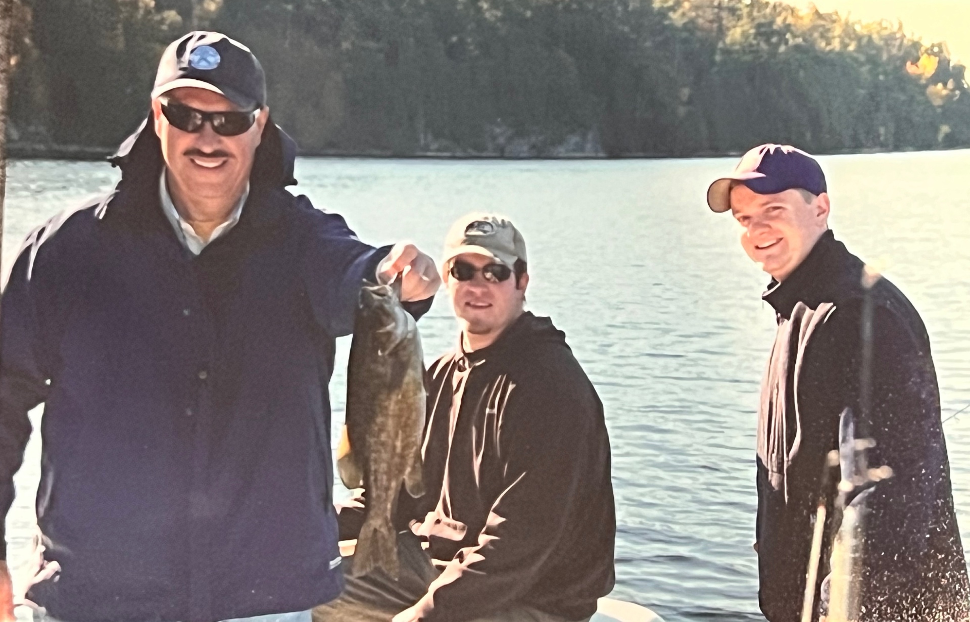 Richard showing off the day's catch with the boys — that mustache-grin says it all