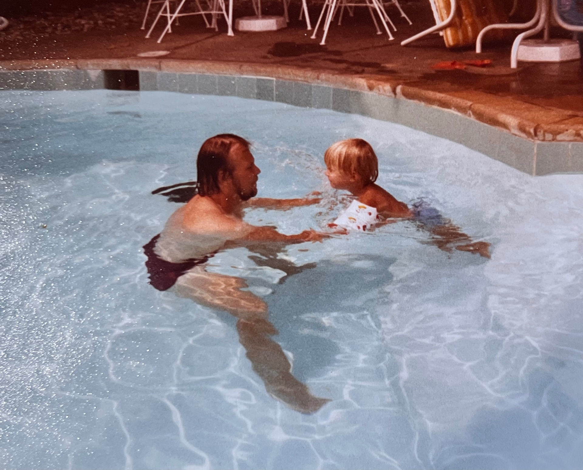 Teaching his little one to swim — the kind of afternoon he lived for