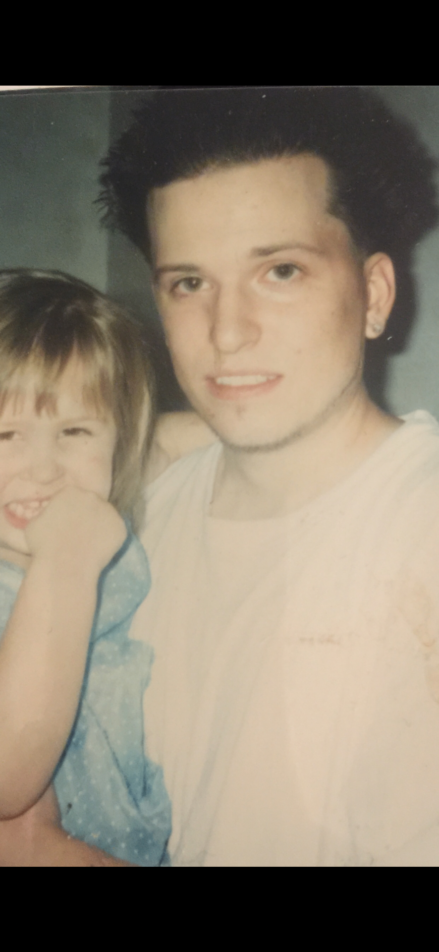 A young dad holding tiny Malayna — the beginning of a beautiful bond