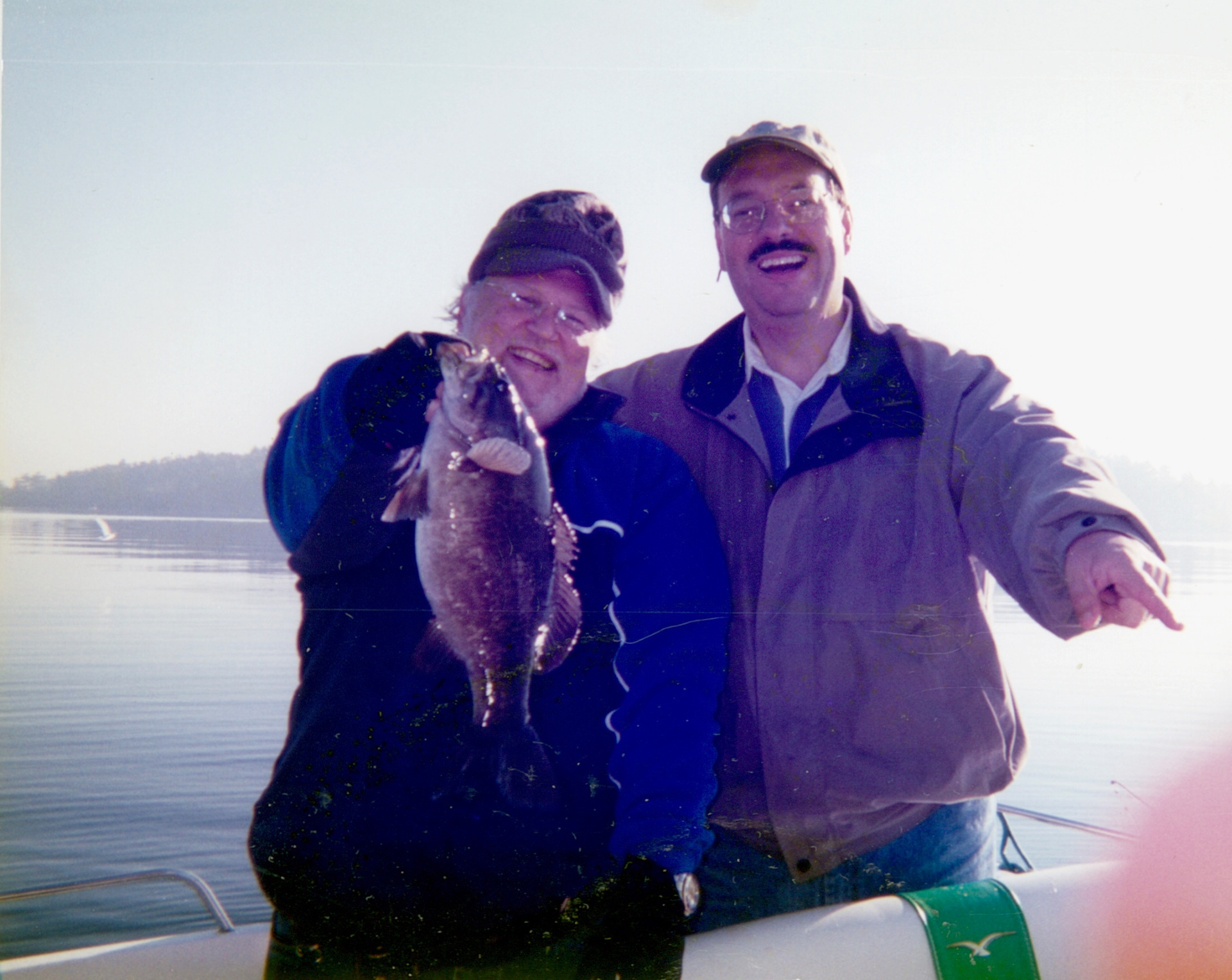Sunrise on the water — laughing with Bob, holding up the first catch of the day