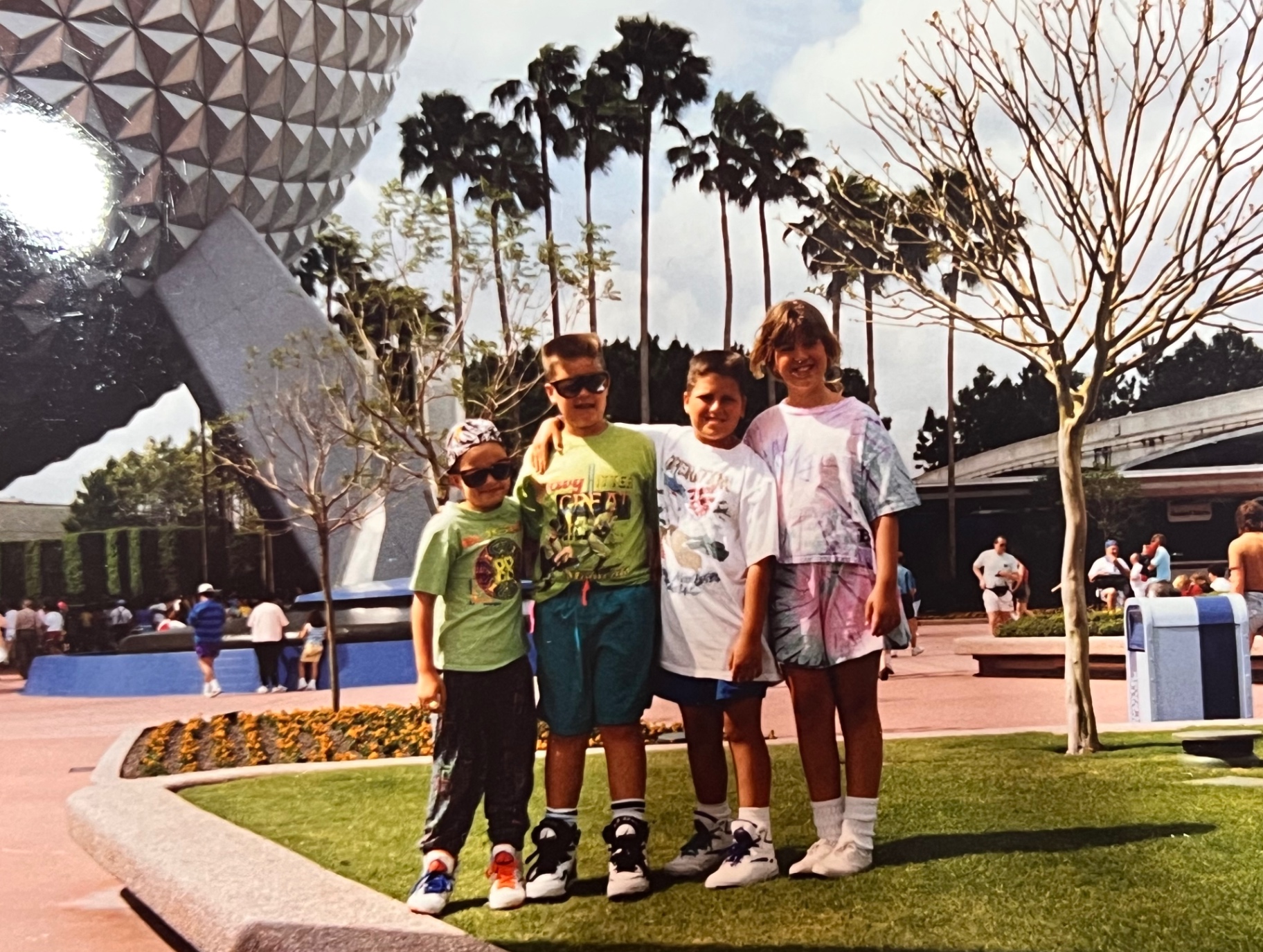 The crew at Epcot — Spaceship Earth behind them, sunshine, and Dad taking the picture