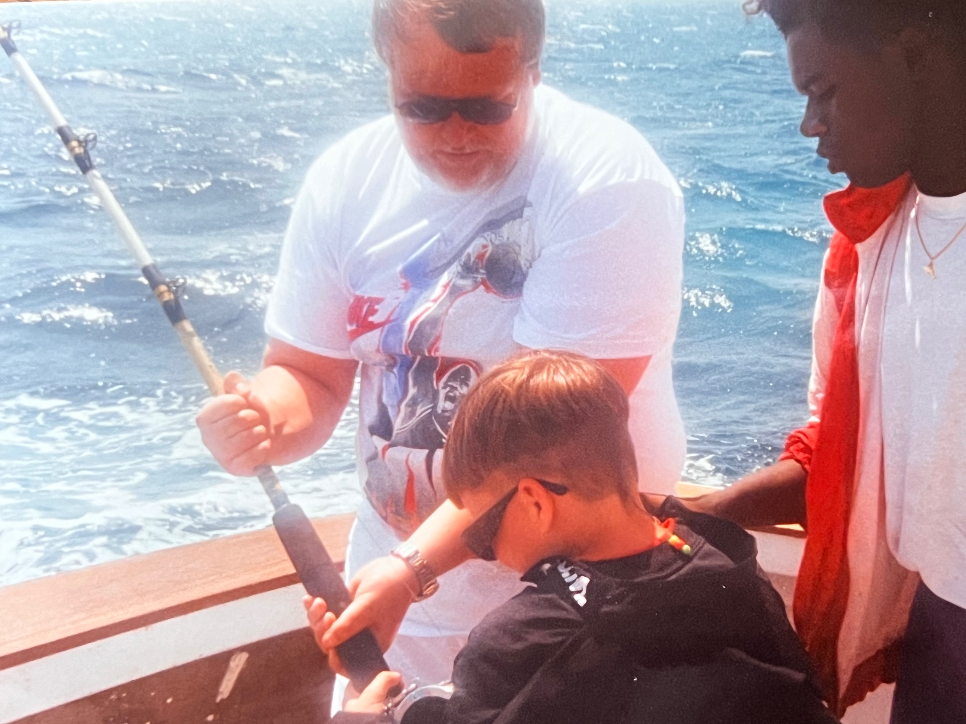 Deep sea with his son — steady hand on the rod, teaching him the ropes on open water