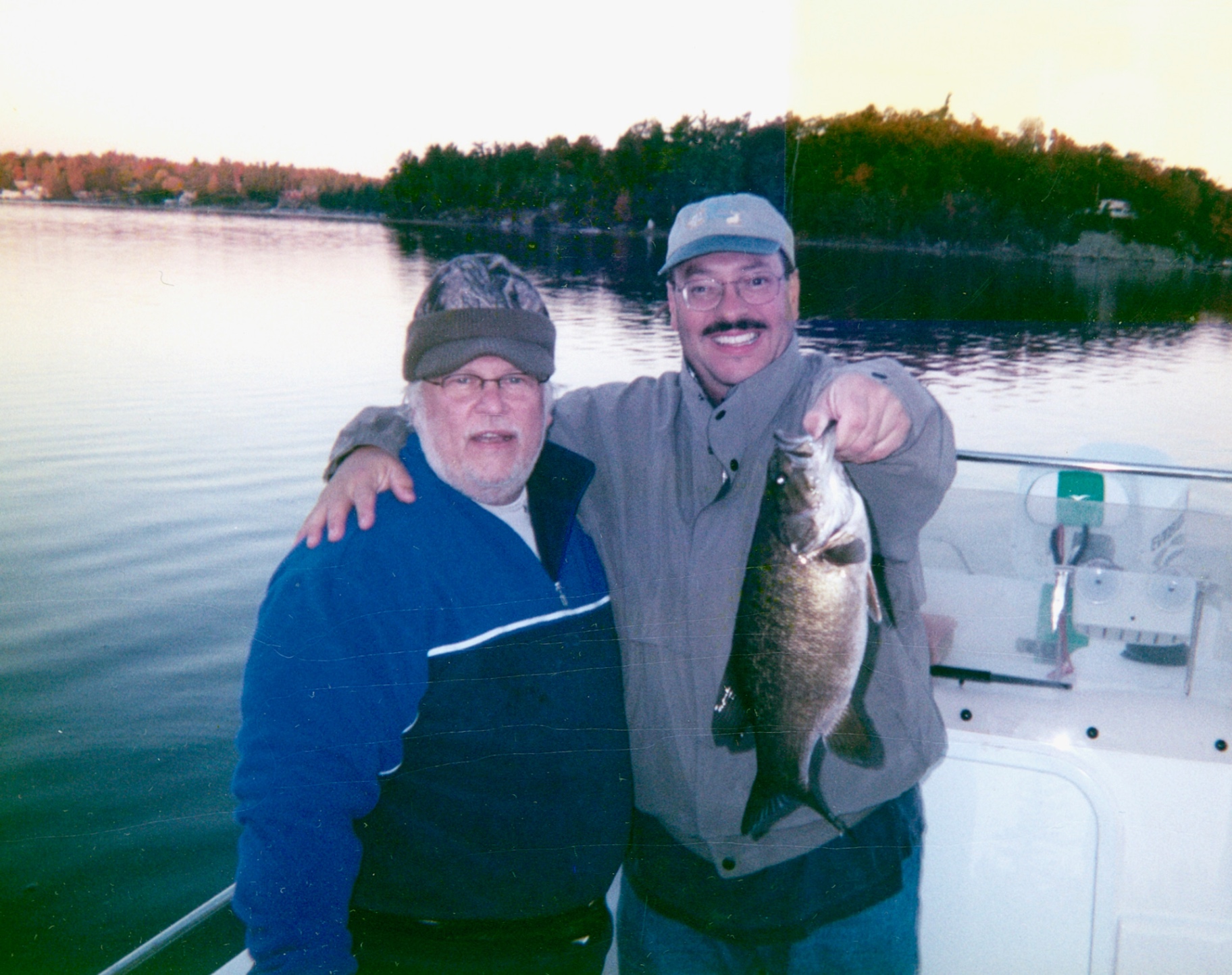 Canada, golden hour on the lake — Richard and his best friend Bob with a trophy bass. The trip he geared up for a month in advance every year